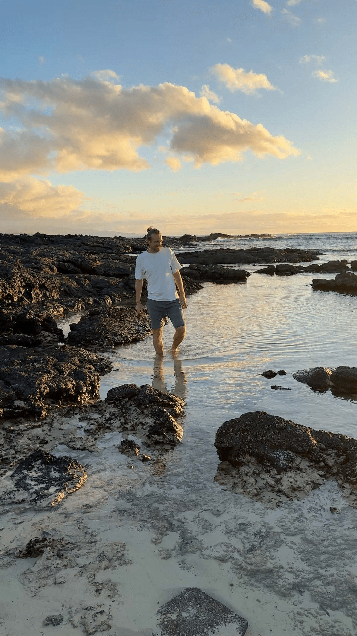 Mann am Strand mit den Füßen im Wasser